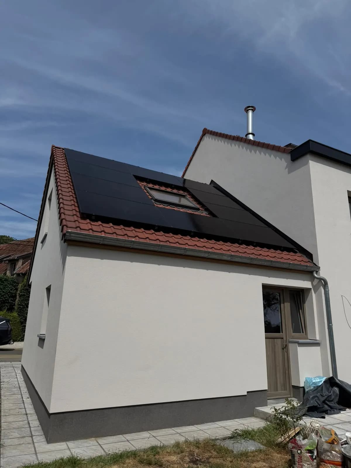 Zwarte zonnepanelen rond een dakraam