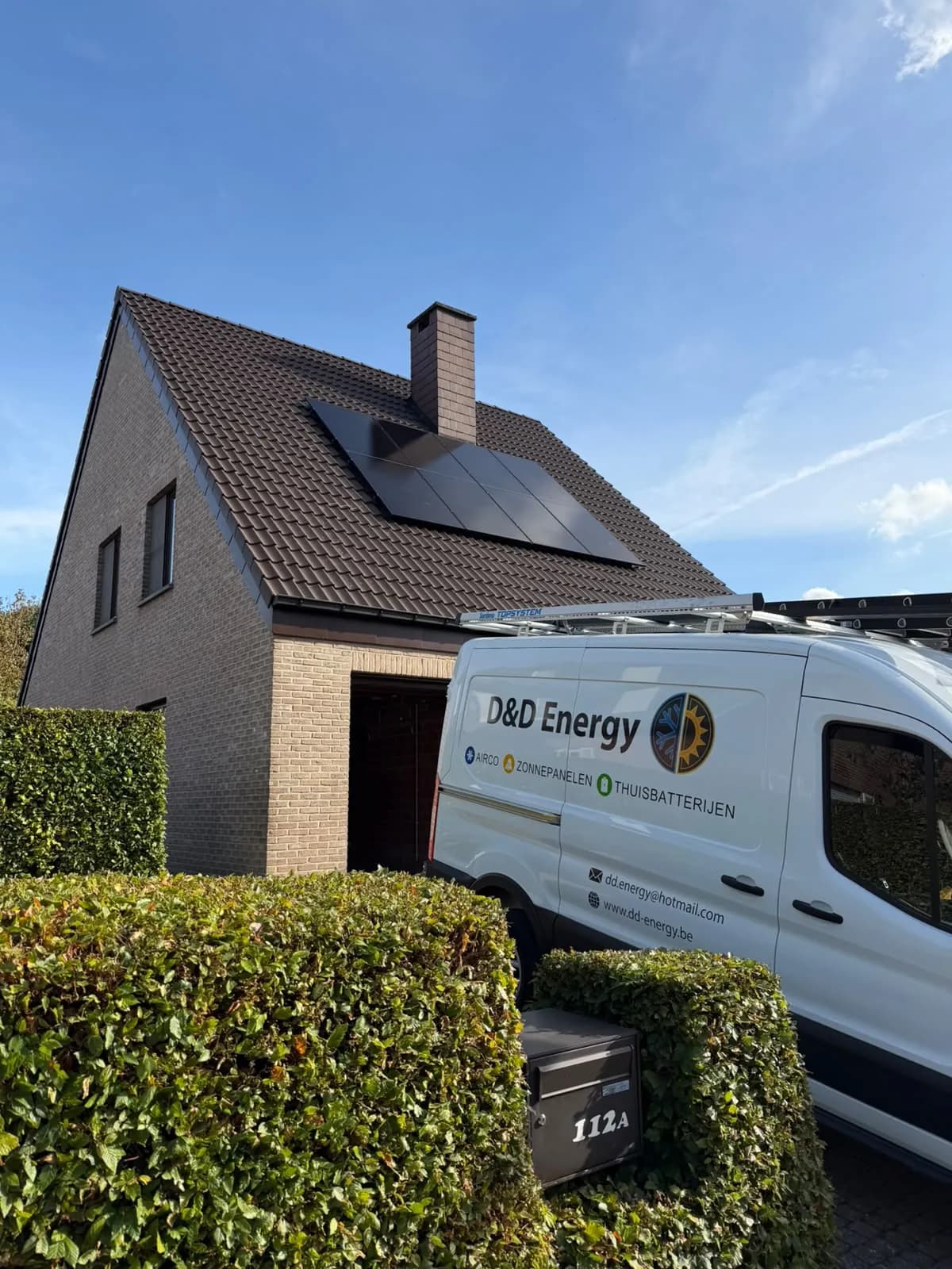 Zwarte zonnepanelen op pannendak met D&D Energy bestelwagen